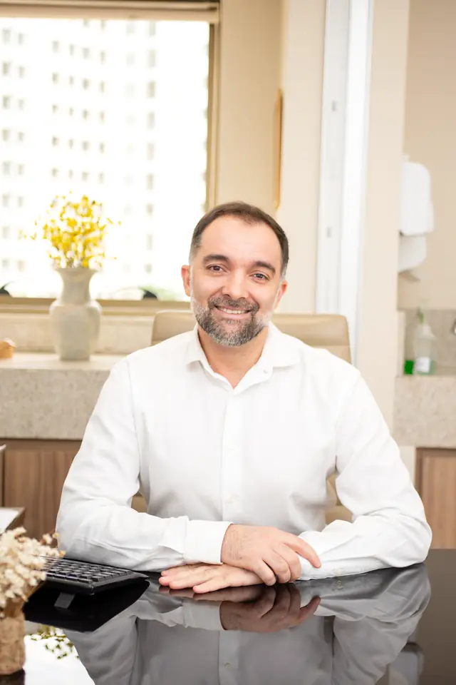 Dr. Daniel Dutra, endocrinologista em Belo Horizonte, sentado à mesa do consultório no Espaço Integrar BH